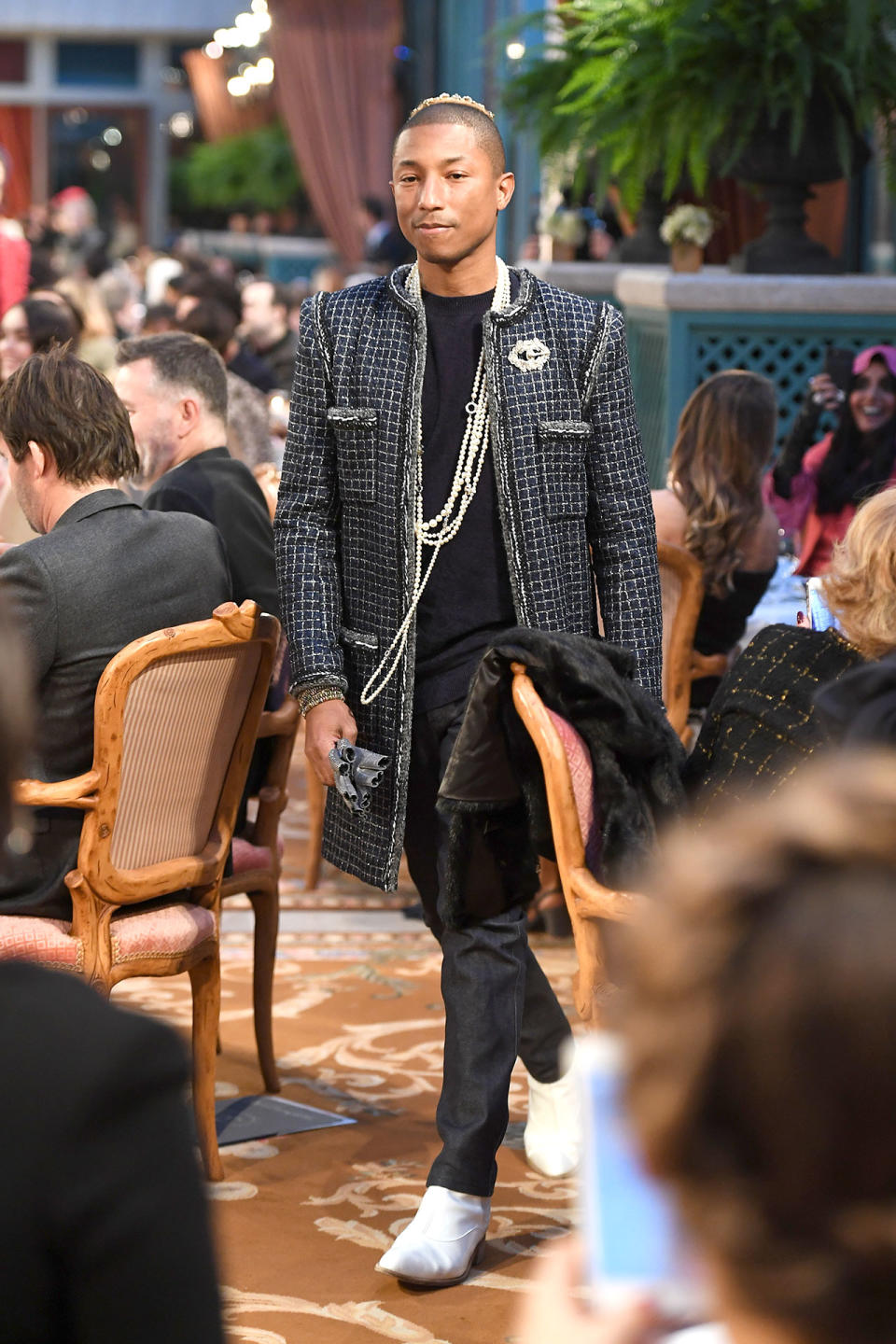 <p>Pharrell models a classic Chanel tweed jacket and strands of pearls.</p> <h4>Getty Images</h4>