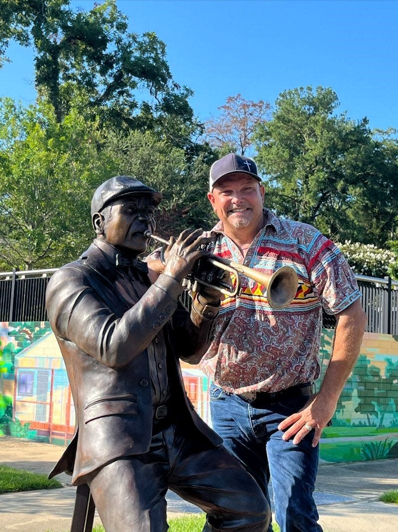 Sculptor Bradley Cooper Jr. poses with his “The Jazz Man” sculpture, located at the market area near the FAMU Way playground.
