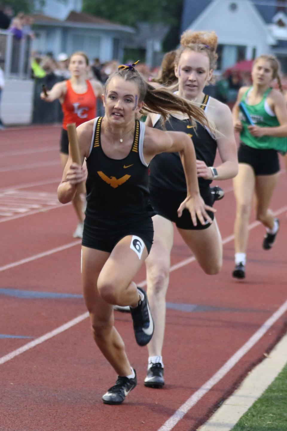 Colonel Crawford's Mira Holt takes the baton from Rylee Ritzhaupt in the 4x400 relay.