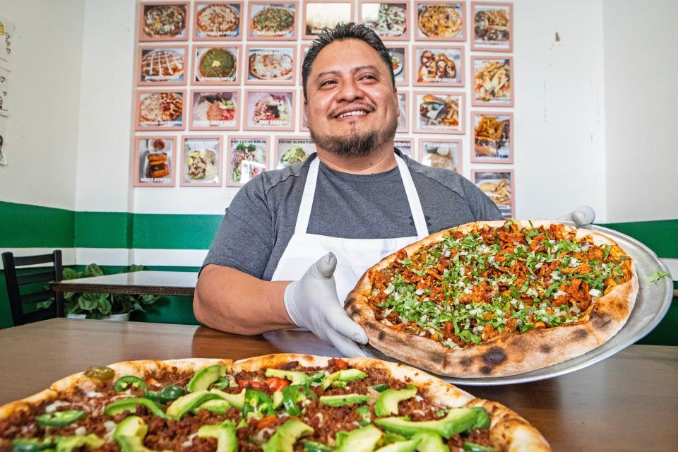 Chef Valentin Palillero shows his "Pizza al Pastor" pie, a crowd-favorite, at San Lucas Pizzeria, the restaurant Palillero co-owns with his wife, Eva Mendez, since 2005, in Philadelphia, Tuesday, Sept. 19, 2023. Paillero is the first chef known to have made a specialty out of Mexican pizza in South Philly.