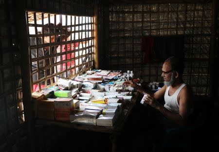 Noor Islam, who was from Taung Bazar village in Myanmar's Buthidaung township, sits at a table displaying medicine for sale at the Kutupalong camp in Cox's Bazar, Bangladesh, October 13, 2018. Picture taken October 13, 2018. REUTERS/Mohammad Ponir Hossain/Files