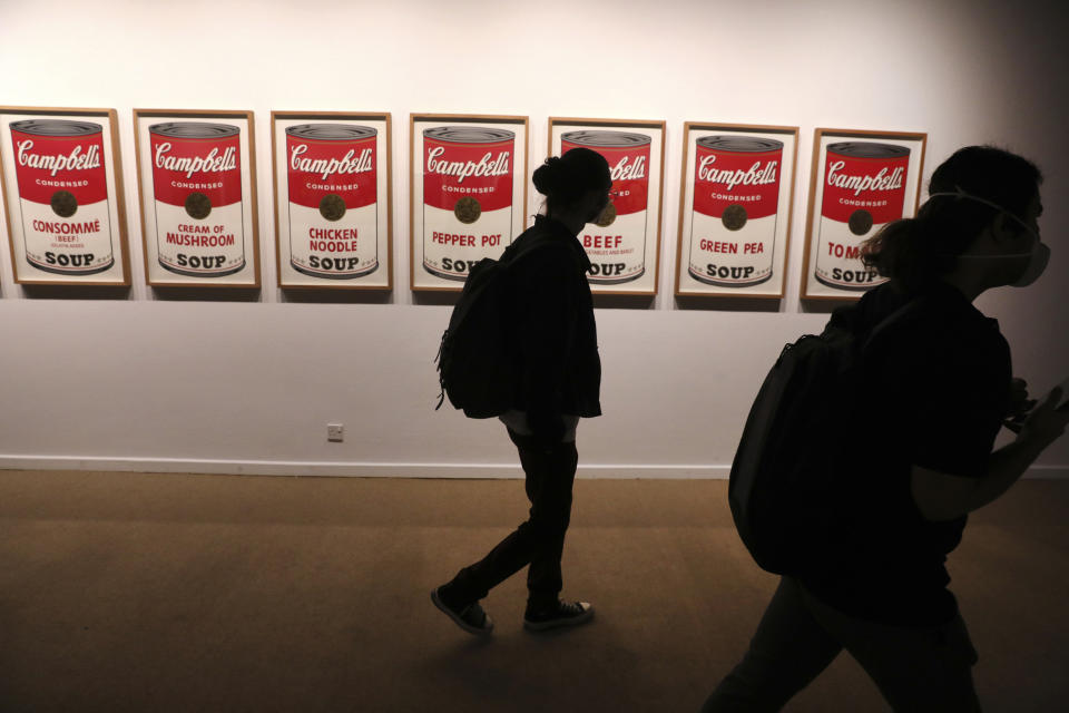 Visitors walk past Campbell's Soup Cans synthetic polymer paints on canvases by American artist Andy Warhol at Tehran Museum of Contemporary Art in Tehran, Iran on Oct. 19, 2021. Iranians are flocking to Tehran's contemporary art museum to marvel at American pop artist Andy Warhol’s iconic work. (AP Photo/Vahid Salemi)