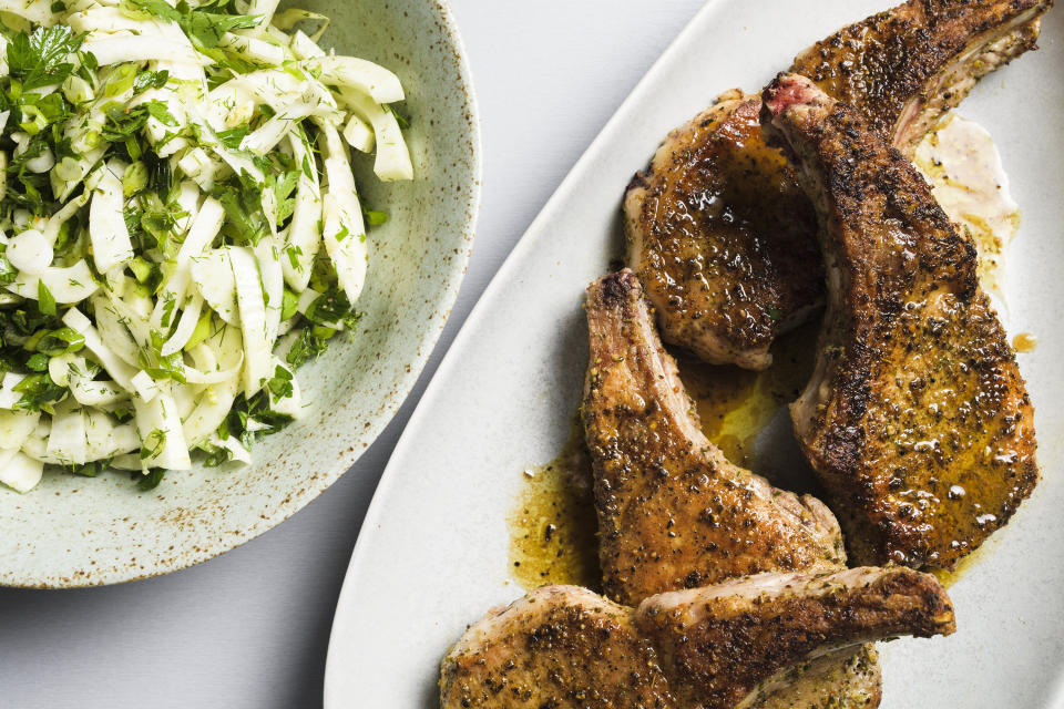This image released by Milk Street shows a recipe for seared pork chops with fennel and herb salad. (Milk Street via AP)