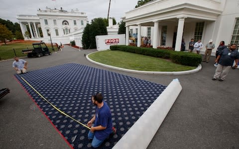 Workmen prepare new carpeting for the West Wing of the White House in Washington, Friday, Aug. 11, 2017, as it undergoes renovations while President Donald Trump is spending time at his golf resort in New Jersey - Credit: AP