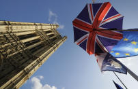 Flags and an umbrella are tied to raiings opposite Britain's parliament buildings in London, Tuesday, Oct. 22, 2019. British lawmakers from across the political spectrum were plotting Tuesday to put the brakes on Prime Minister Boris Johnson's drive to push his European Union divorce bill through the House of Commons in just three days, potentially scuttling the government's hopes of delivering Brexit by Oct. 31. (AP Photo/Kirsty Wigglesworth)