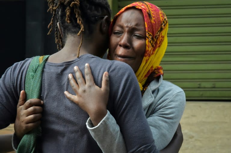 Relatives sob as they identify the bodies of the victims of the bomb and gun attack on a hotel complex in Kenya