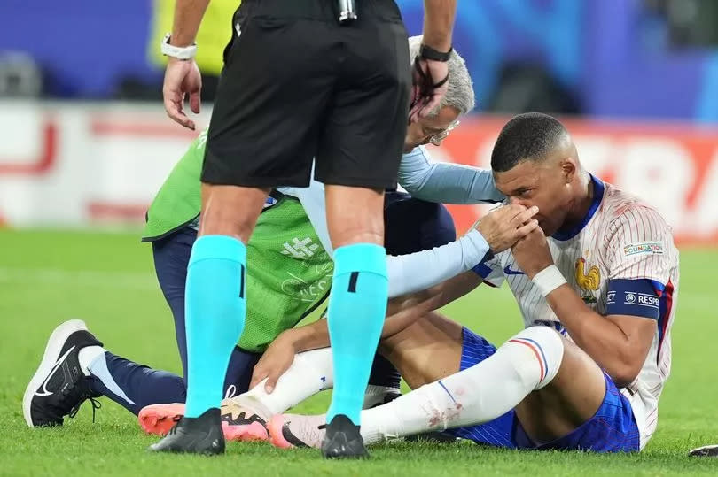 Medical staff help Kylian Mbappe (10) of France after he hits his nose to his rival's shoulder during the 2024 European Football Championship (EURO 2024) Group D football match between France and Austria at Merkur Spiel-Arena in Dusseldorf, Germany on June 17, 2024.