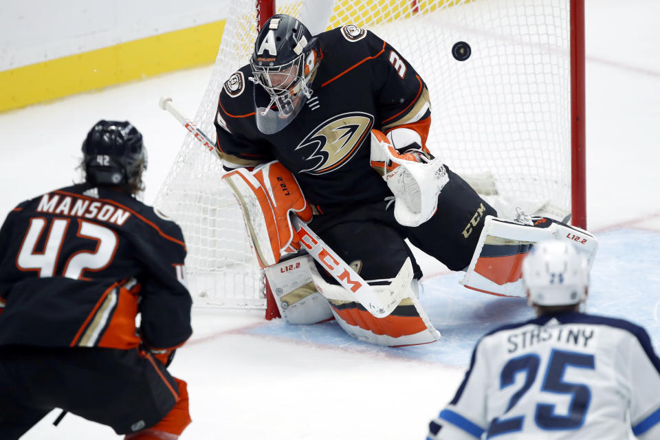 The puck gets by Anaheim Ducks goaltender John Gibson, center, on a shot by Winnipeg Jets left wing Nikolaj Ehlers, not pictured, with defenseman Josh Manson, left, and center Paul Stastny, right, watching during the third period of an NHL hockey game in Anaheim, Calif., Tuesday, Oct. 26, 2021. (AP Photo/Alex Gallardo)