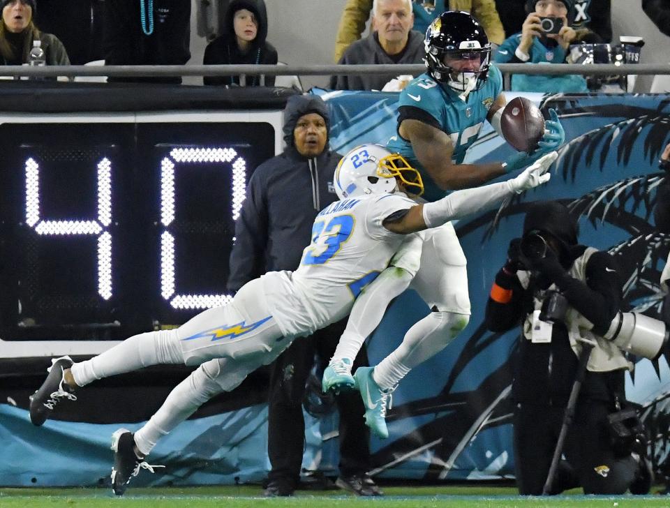 Jacksonville Jaguars wide receiver Christian Kirk (13) pulls in a pass for a touchdown while being defended by Los Angeles Chargers cornerback Bryce Callahan (23) to make it a four point game with just under five and a half minutes to play in the game. A two point conversion after the touchdown put the Jaguars with two points of the Chargers. The Jacksonville Jaguars hosted the Los Angeles Chargers in their first round playoff game Saturday, January 14, 2023 at TIAA Bank Field in Jacksonville, Fla. The Jaguars trailed 27 to 7 at the half but came back to win the game 31 to 30. [Bob Self/Florida Times-Union]