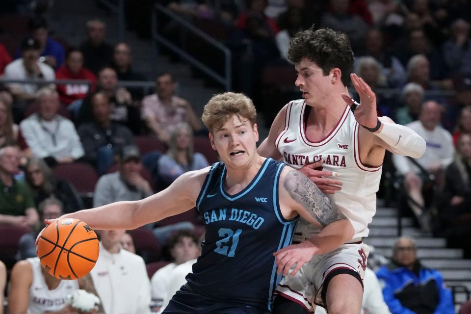 March 9, 2024; Las Vegas, NV, USA; San Diego Toreros forward PJ Hayes (21) dribbles the basketball against Santa Clara Broncos forward Johnny O'Neil (14) during the first half in the quarterfinals of the WCC Basketball Championship at Orleans Arena.