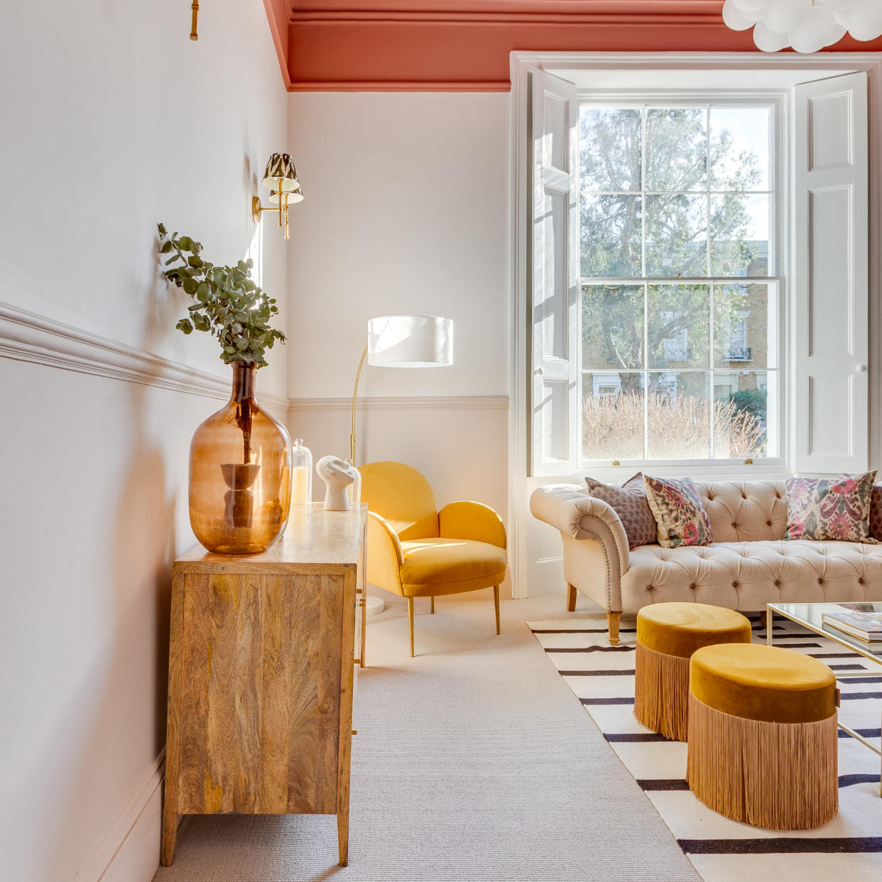  Neutral living room with orange-pink pops of colours. 