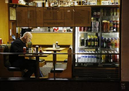 A man sits in a cafe in London November 13, 2012. REUTERS/Luke MacGregor