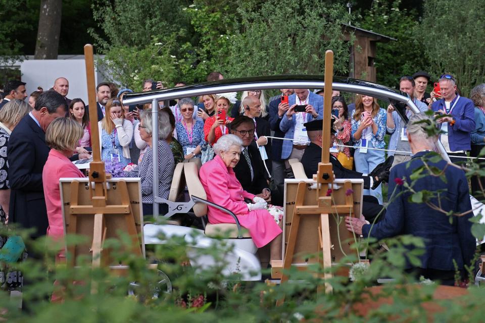 Britain's Queen Elizabeth II (C) is given a tour of the 2022 RHS Chelsea Flower Show in London on May 23, 2022. - The Chelsea flower show is held annually in the grounds of the Royal Hospital Chelsea.