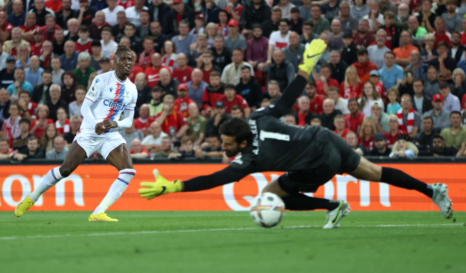 Seen here, Crystal Palace forward Wilfried Zaha scores the opening goal at Anfield after firing past Alisson Becker in the Liverpool goal.