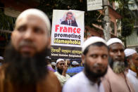 Supporters of Islami Andolan Bangladesh, an Islamist political party, carry a defaced poster of French President Emmanuel Macron as they protest against the publishing of caricatures of the Prophet Muhammad they deem blasphemous, in Dhaka, Bangladesh, Tuesday, Oct. 27, 2020. Muslims in the Middle East and beyond on Monday called for boycotts of French products and for protests over the caricatures, but Macron has vowed his country will not back down from its secular ideals and defense of free speech. (AP Photo/Mahmud Hossain Opu)