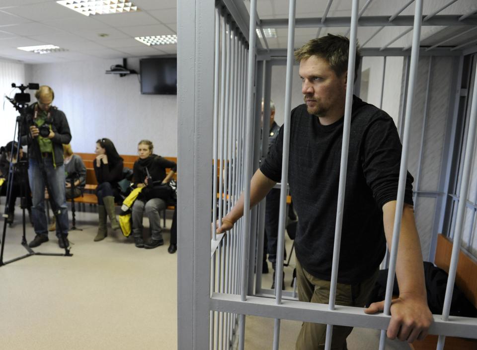 Greenpeace activist Anthony Perrett from Britain looks out from a defendants' box at a district court in Murmansk