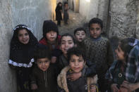 Internally displaced children pose for a photograph outside their temporary home in the city of Kabul, Afghanistan, Wednesday, Dec. 30, 2020. Save the Children has warned that more than 300,000 Afghan children face freezing winter conditions that could lead to illness, in the worst cases death, without proper winter clothing and heating. (AP Photo/Rahmat Gul)