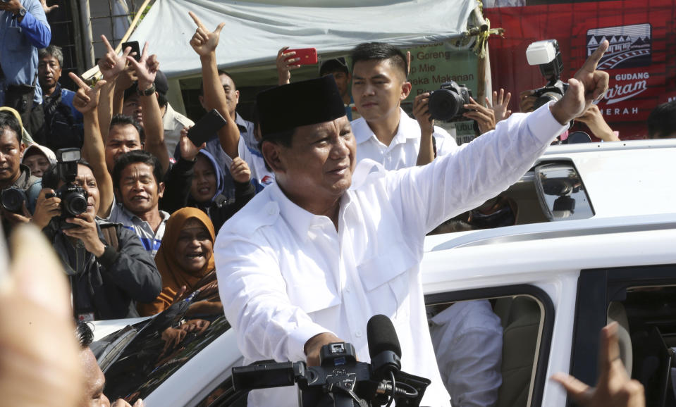 Indonesian presidential candidate Prabowo Subianto greets to his supporters after casting his vote at a polling station in Bogor, Indonesia, Wednesday, April 17, 2019. Tens of millions of Indonesians were voting in presidential and legislative elections Wednesday after a campaign that pitted the moderate incumbent against an ultranationalist former general whose fear-based rhetoric warned the country would fall apart without his strongman leadership. (AP Photo/Achmad Ibrahim)