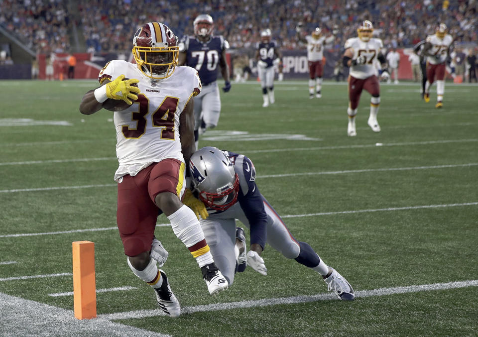 Washington Redskins running back Byron Marshall (34) scores a touchdown in front of New England Patriots defensive back Duron Harmon (21) during the first half of a preseason NFL football game, Thursday, Aug. 9, 2018, in Foxborough, Mass. (AP Photo/Charles Krupa)