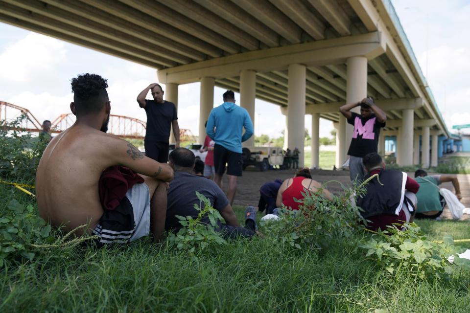 FILE - Migrants wait to be processed by the Border Patrol after illegally crossing the Rio Grande River from Mexico into the United States at Eagle Pass, Texas, Friday, Aug. 26, 2022. Venezuelans have surpassed Guatemalans and Hondurans to become the second-largest nationality stopped at the U.S. border in August 2022 after Mexicans. (AP Photo/Eric Gay, File)