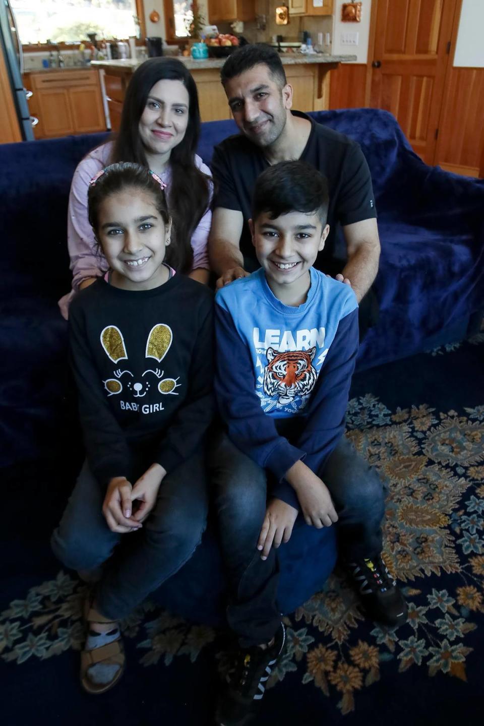 Negina Barakazai and her husband, Kawa Barakazai, pose for a picture with their 8-year-old daughter Maryam and 12-year-old son Ben Yamin in their new Cambria home. The Barakazai family spent more than two years in hiding in Afghanistan and Pakistan before arriving in the United States on Sept. 6, 2023.