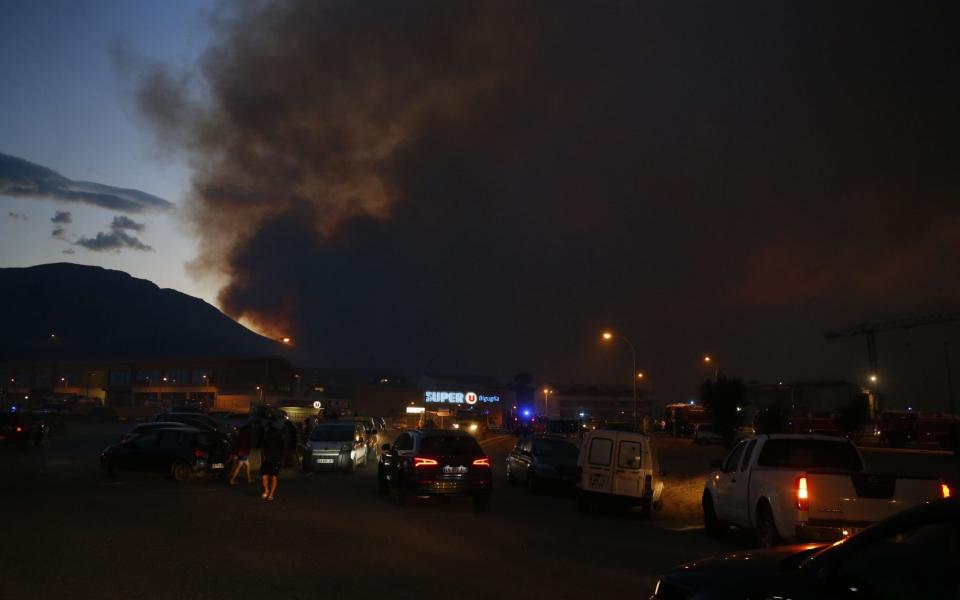 A picture taken on July 24, 2017 shows smoke billowing over the city of Biguglia on the French Mediterranean island of Corsica - Credit: AFP