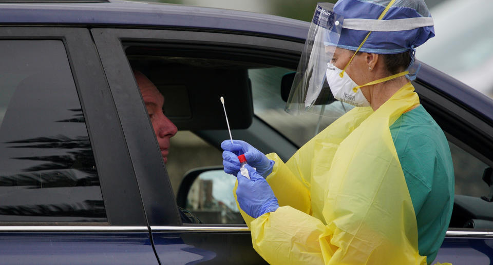 A medical staff member administers tests for the coronavirus disease. Source: AAP