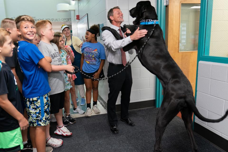 Scott McWilliams, superintendent of Auburn-Washburn Schools, holds up Bailey, his 2-year-old great dane, in front of a class of six graders at Indian Hills Elementary Wednesday morning.