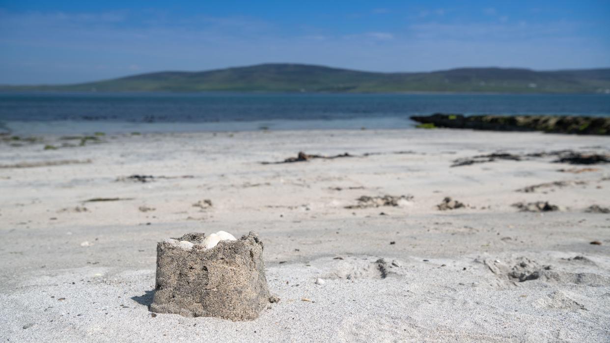 Small sandcastle on a sandy beach in Orkney, Scotland, UK.