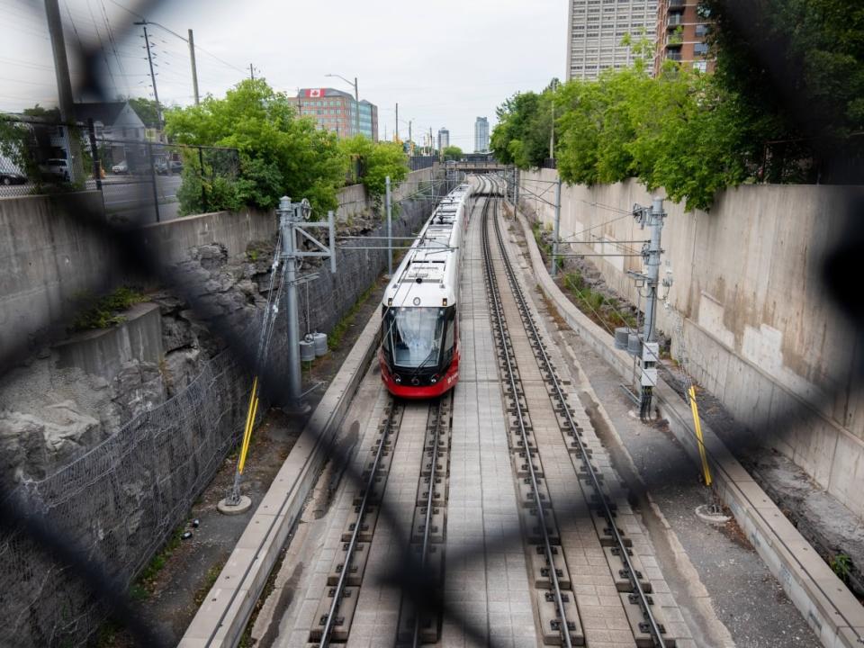 An Ottawa light rail train drives along the Confederation Line last month. Transit advocates are irked at news the handover of the western LRT expansion could be delayed by as much as a year. (Spencer Colby/The Canadian Press - image credit)