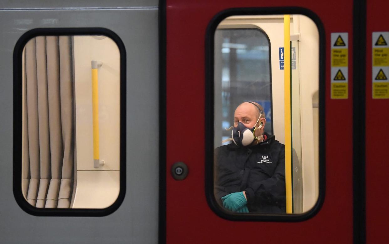 A member of the public wears a a protective mask on the Tube in London - Getty