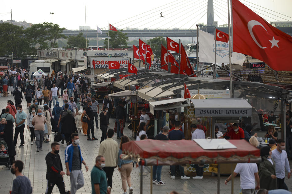 People walk in Eminonu, in Istanbul, Friday, May 28, 2021, hours before the start of a weekend curfew. (AP Photo/Emrah Gurel)