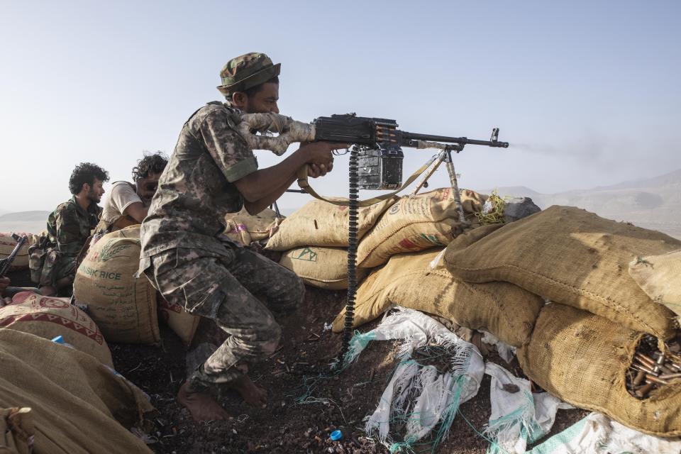 FILE - A Yemeni fighter backed by the Saudi-led coalition fires his weapon during clashes with Houthi rebels on the Kassara frontline near Marib, Yemen, June 20, 2021. A stark warning from international charity group Oxfam on Tuesday, Feb. 8, 2022, said a yearlong battle over the strategic Yemeni city of Marib has displaced about 100,000 people and underscored how the fighting has worsened an already dire humanitarian situation. (AP Photo/Nariman El-Mofty, File)