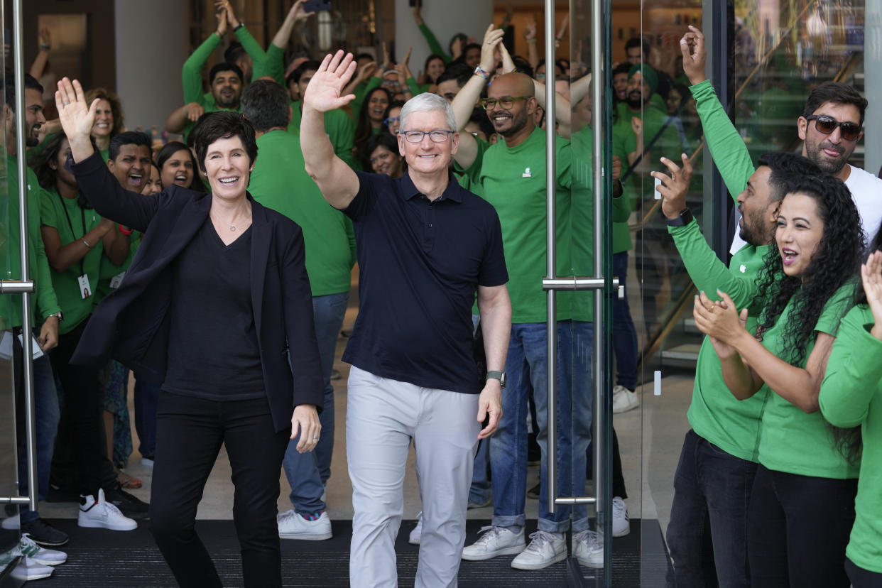 Apple CEO Tim Cook, center, along with Senior Vice president of retail Deirdre O'Brien, left, wave to people during the opening of the first Apple Inc. flagship store in Mumbai, India, Tuesday, April 18, 2023. Apple Inc. opened its first flagship store in India in a much-anticipated launch Tuesday that highlights the company’s growing aspirations to expand in the country it also hopes to turn into a potential manufacturing hub. (AP Photo/Rafiq Maqbool)
