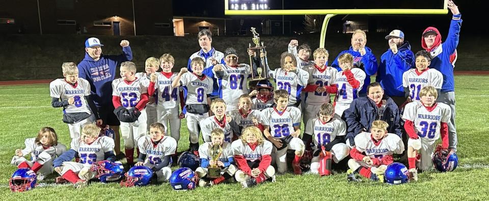 Members of the Little Warriors third- and fourth-grade football team celebrate after Saturday's 8-2 win over Merrimack in the Northeast Junior Football League Division I championship at Winnacunnet High School.