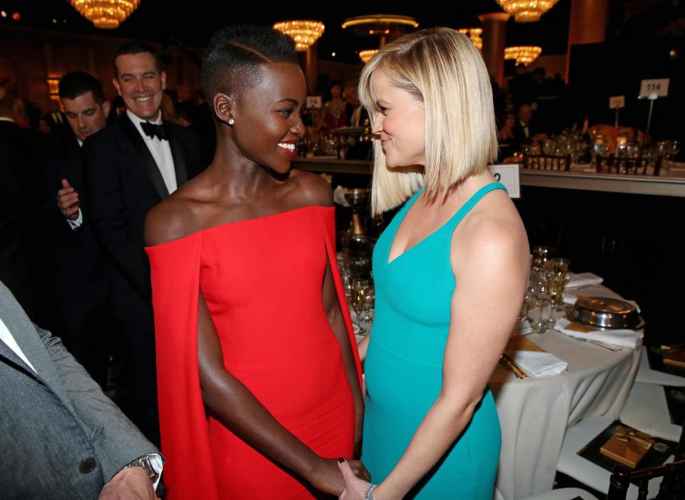 Lupita Nyong'o, left, and Reese Witherspoon speak in the audience at the 71st annual Golden Globe Awards at the Beverly Hilton Hotel on Sunday, Jan. 12, 2014, in Beverly Hills, Calif. (Photo by Matt Sayles/Invision/AP)