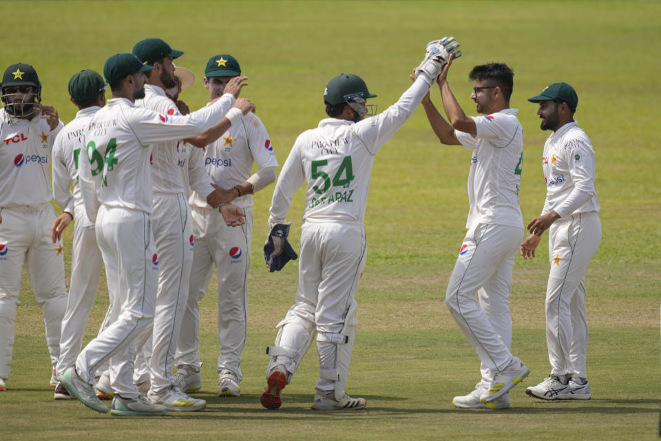 Pakistan's team members congratulate their bowler Abrar Ahmed, second right, for the wicket of Sri Lanka's Dimuth Karunaratne during the fourth day of the first cricket test match between Sri Lanka and Pakistan in Galle, Sri Lanka, Wednesday, July 19, 2023. (AP Photo/Eranga Jayawardena)