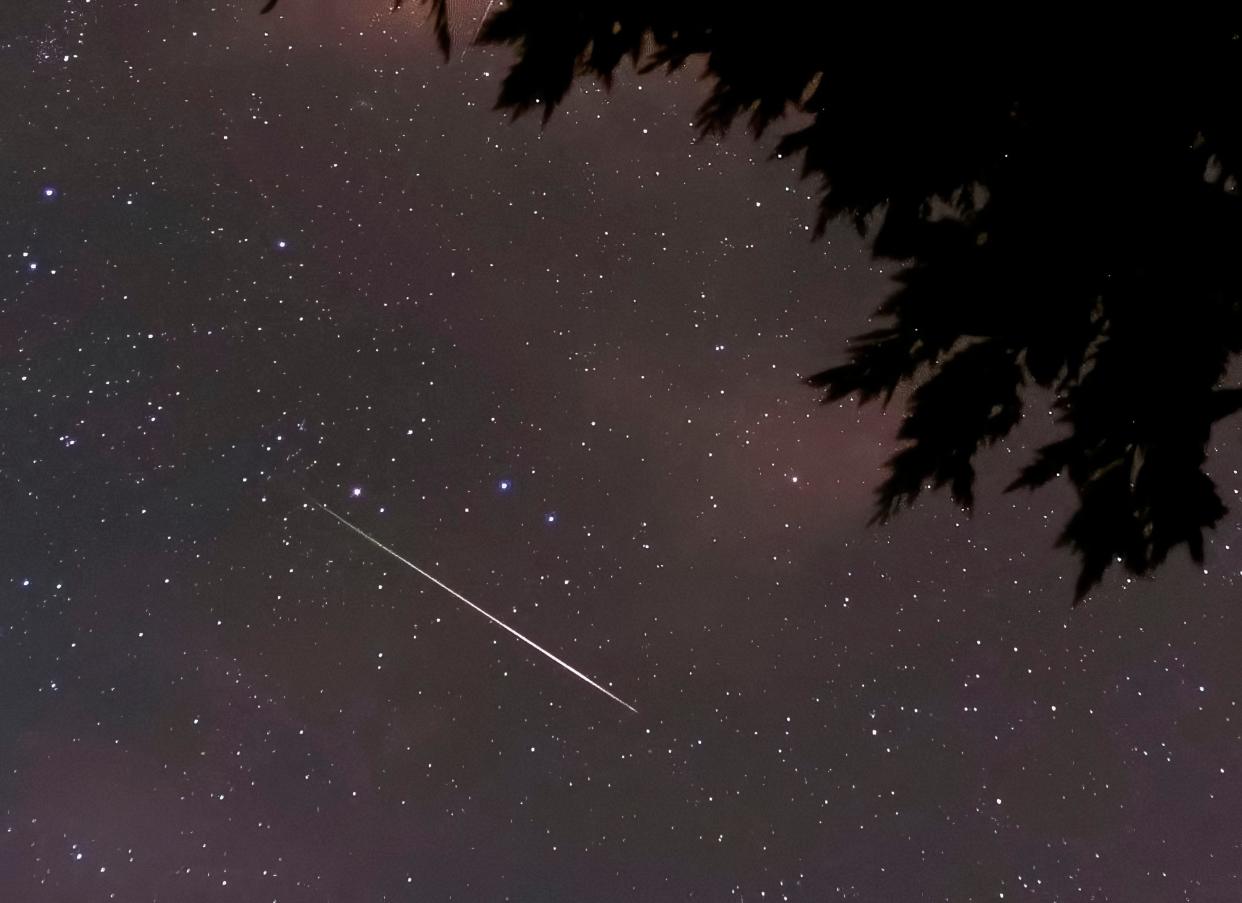 A Perseid meteor streaks across the early morning sky during the Perseid meteor shower in 2015. Dark, moonless skies may permit many Perseid meteors to be seen early on the morning of Aug. 13.