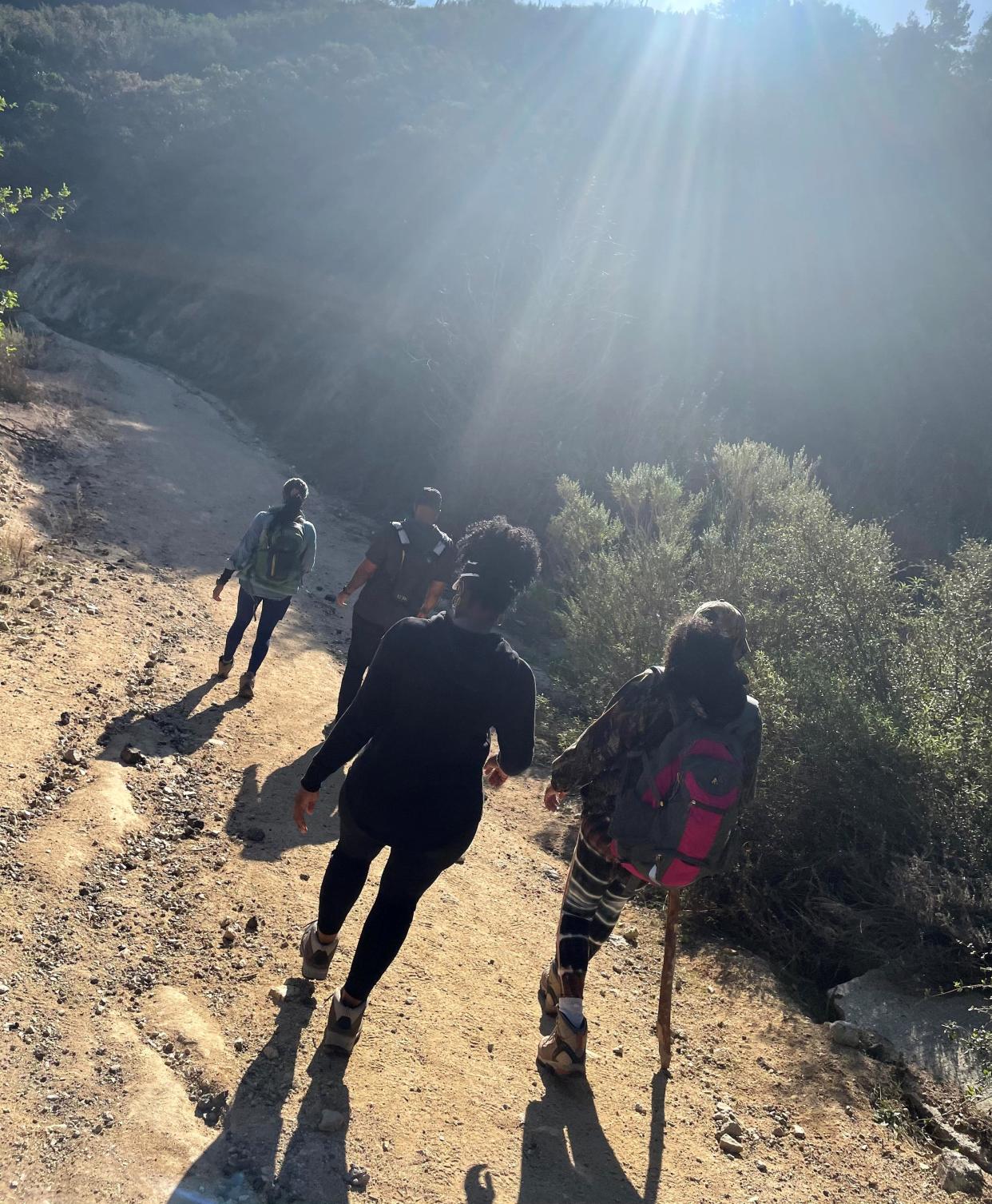 Robert Gipson hikes along with program participates Moya Allen, Tiffaney Collier and Nikoi Williams on the Gould Mesa Trail in the San Gabriel Mountains in 2023.
