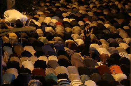 Palestinian men take part in evening prayers inside Jerusalem's Old City, next to the Lion's Gate, July 24, 2017. REUTERS/Ammar Awad