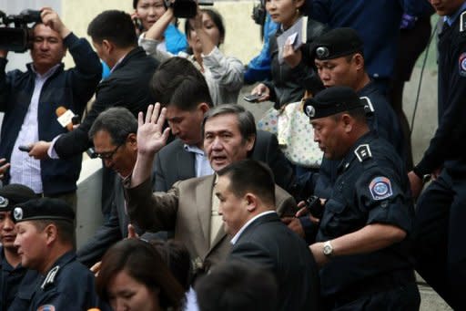 Former Mongolian leader Nambar Enkhbayar (C) waves as he leaves court in Ulan Bator in June 2012. On Thursday, a Mongolian court found him guilty of misappropriating gifts intended for a monastery, along with other corruption charges, in a hearing broadcast to the nation