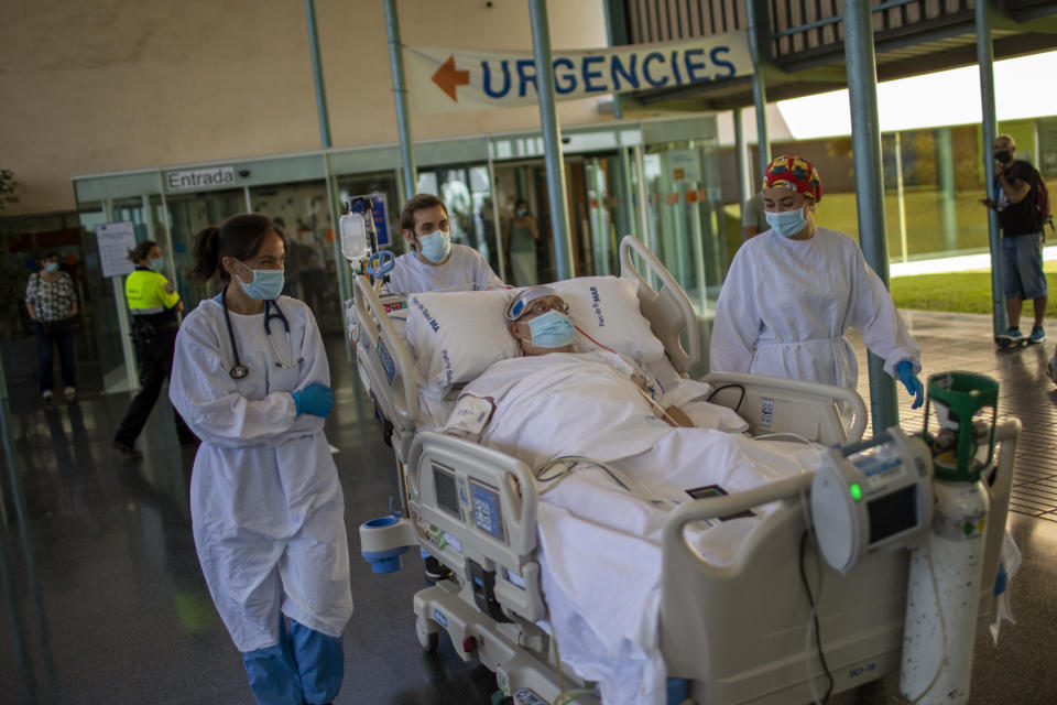 Medical staff transport Francisco España, 60, to see the Mediterranean sea, at the "Hospital del Mar" in Barcelona, Spain, Friday, Sept. 4, 2020. A hospital in Barcelona is studying how short trips to the beach may help COVID-19 patients recover from long and traumatic intensive hospital care. The study is part of a program to “humanize” ICUs. Since re-starting it in early June, the researchers have anecdotally noticed that even ten minutes in front of the blue sea waters can improve a patient’s emotional attitude. (AP Photo/Emilio Morenatti)