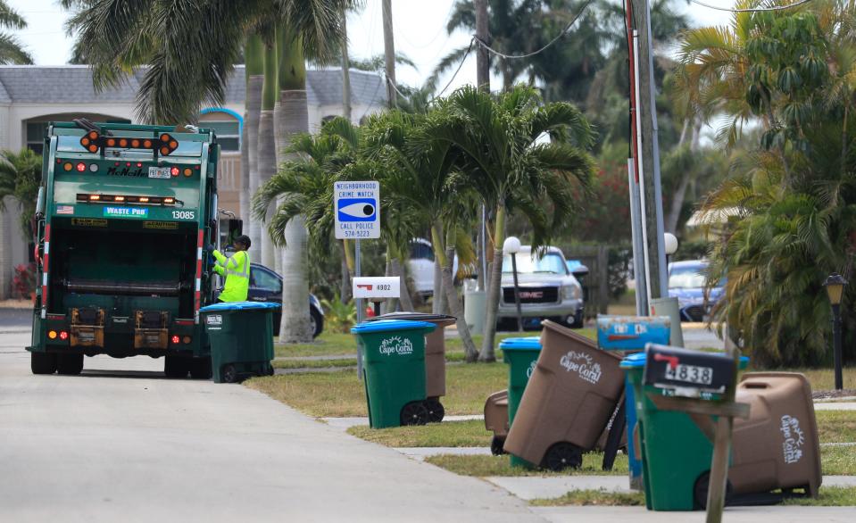 A Waste Pro garbage truck collects trash along a neighborhood south of Cape Coral Parkway Monday, April 5, 2021.