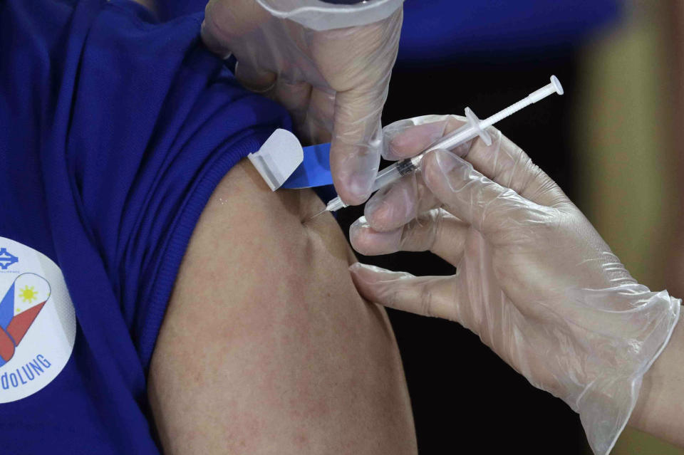 A health worker injects China's Sinovac vaccine on his colleague during the first batch of vaccination at the Lung Center of the Philippines in Quezon city, Philippines on Monday, March 1, 2021. The Philippines launched a vaccination campaign Monday to contain one of Southeast Asia's worst coronavirus outbreaks but faces supply problems and public resistance, which it hopes to ease by inoculating top officials. (AP Photo/Aaron Favila)