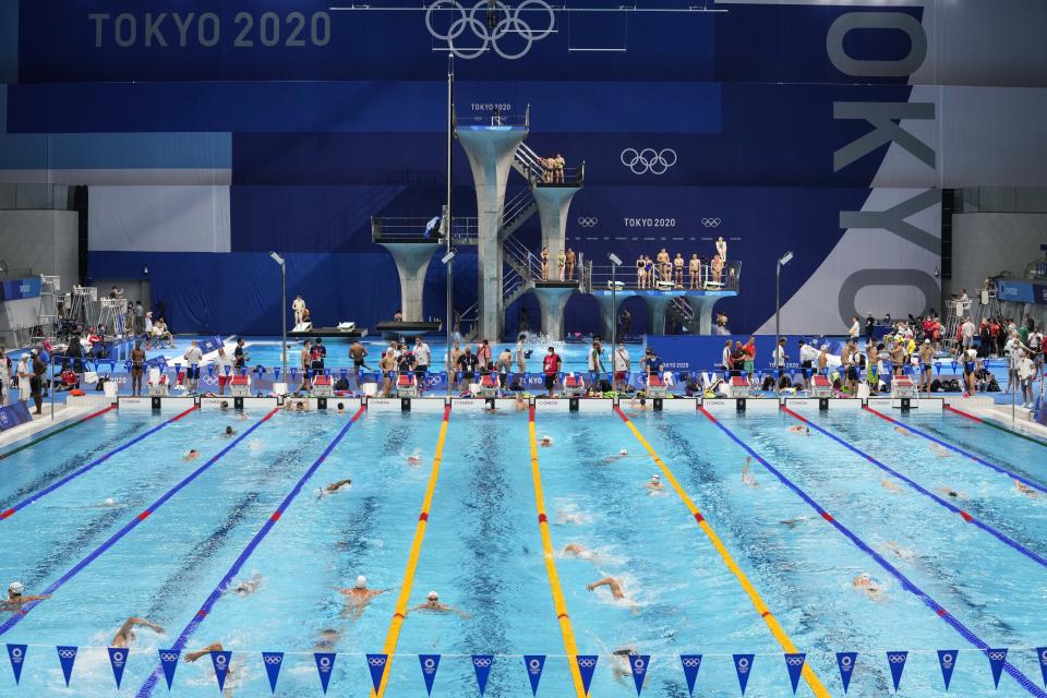 FILE - In this July 23, 201 file photo, Athletes exercise during a swimming training session at the Tokyo Aquatics Centre at the 2020 Summer Olympics, in Tokyo, Japan. The Tokyo Aquatics Centre is a site to behold -- a towering, 15,000-seat venue that will host swimming and diving at the pandemic-delayed Summer Games.(AP Photo/Martin Meissner,File)