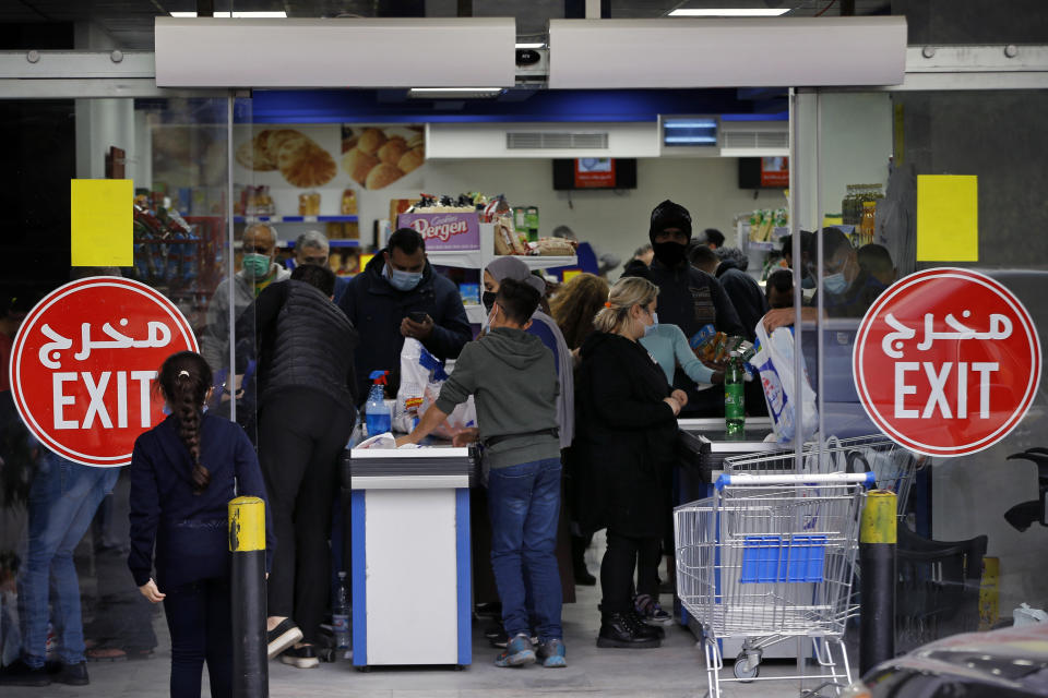 People shop at a supermarket as they begin to stock up on provisions, in Beirut, Lebanon, Monday, Jan. 11, 2021. Panic buyers swarmed supermarkets after reports the government planned to also order them shut in the tightened lockdown. Long lines formed outside chain supermarkets, sparking fear the crowds could further spread the virus. (AP Photo/Bilal Hussein)