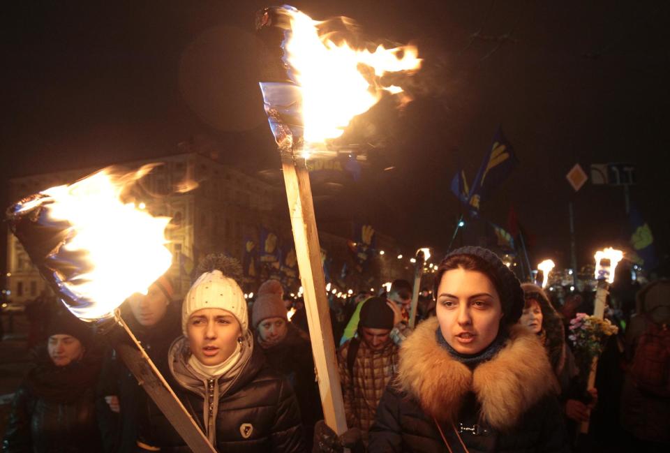 Ukrainian nationalists carry torches during a rally in downtown Kiev, Ukraine, late Wednesday, Jan. 1, 2014. The rally was organized on the occasion of the birth anniversary of Stepan Bandera, founder of a rebel army that fought against the Soviet regime and who was assassinated in Germany in 1959. (AP Photo/Sergei Chuzavkov)