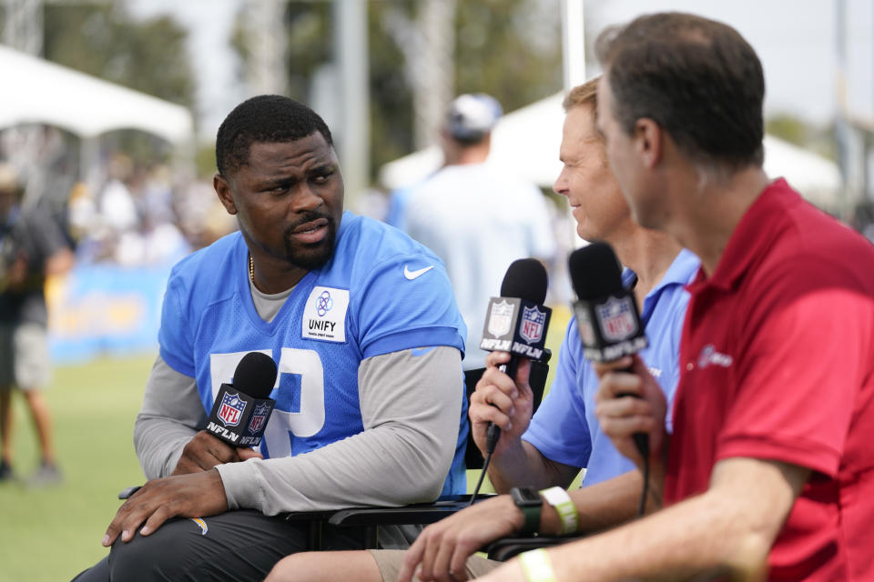 Los Angeles Chargers offensive linebacker Khalil Mack (52) talks with NFL Networks' Matt Smith, center, and Daniel Jeremiah at the NFL football team's practice facility in Costa Mesa, Calif. Saturday, July 30, 2022. (AP Photo/Ashley Landis)