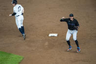 Miami Marlins shortstop Miguel Rojas, right, celebrates after throwing to first for the final out to clinch a playoff berth after the tenth inning of a baseball game against the New York Yankees at Yankee Stadium, Friday, Sept. 25, 2020, in New York. Yankees' Clint Frazier, left, looks back toward first base. (AP Photo/Corey Sipkin)