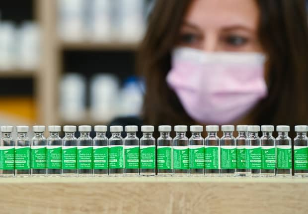 Pharmacist Barbara Violo arranges empty vials of the AstraZeneca vaccine at the Junction Chemist, an independent pharmacy in Toronto, on Monday, April 19, 2021.